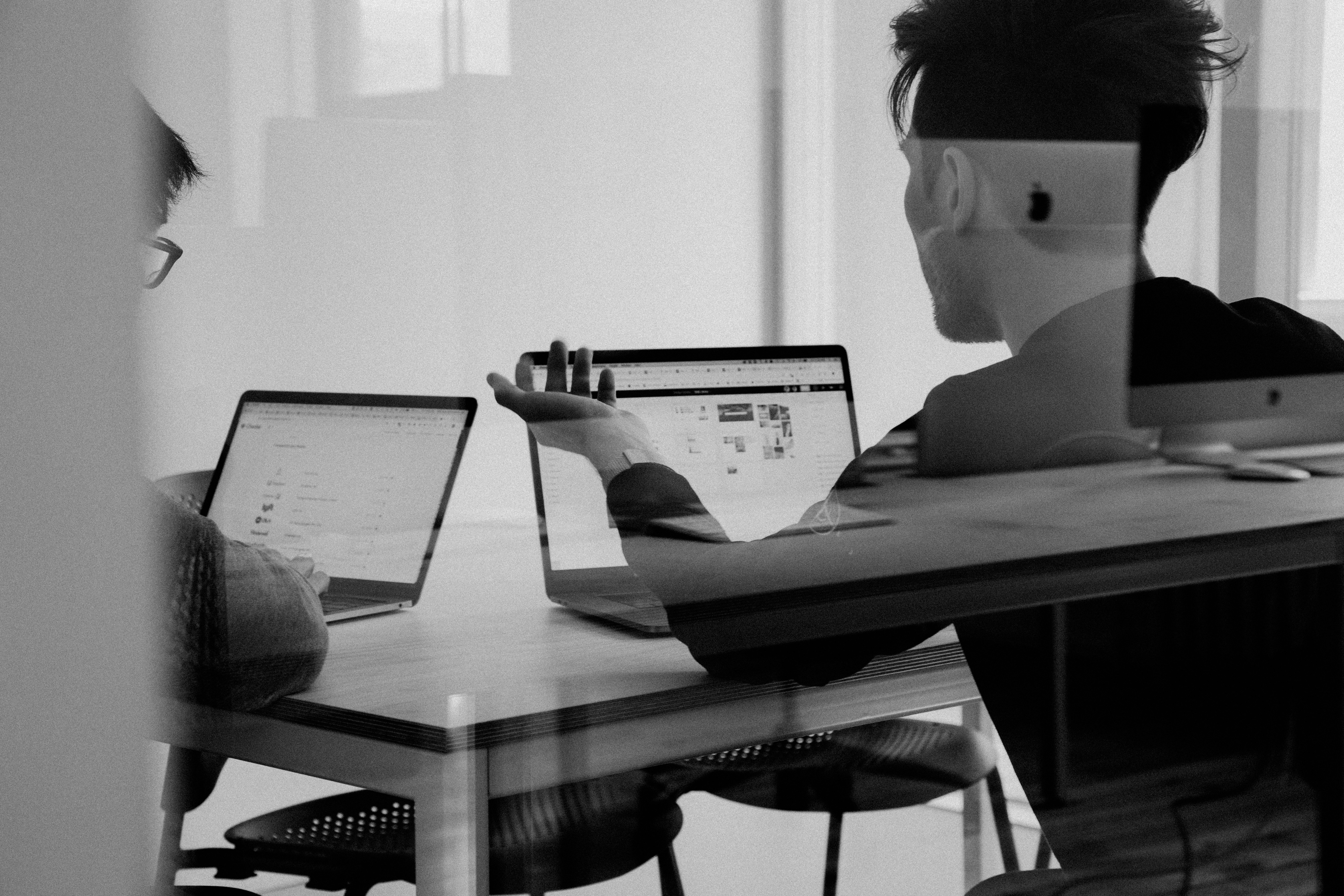 Two brokers in a meeting discussing how to use real-time flight tracking to find the best solutions for their clients.